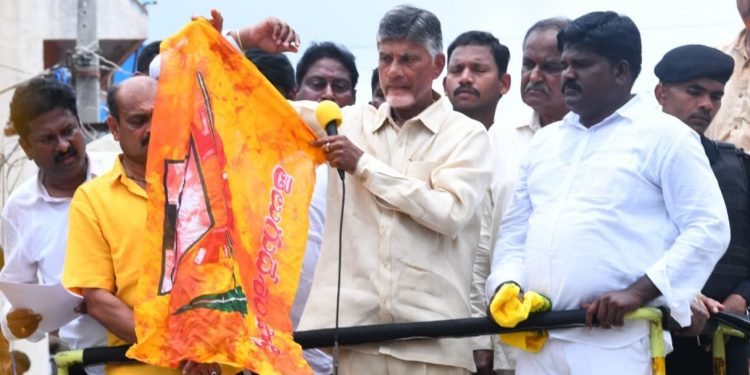 TDP Chief and former Chief Minister of AP, N Chandrababu Naidu showing a TDP flag soaked with his supporter's blood at the roadshow in Kuppam on Thursday, 25 August. (iTDP_Official/Twitter)