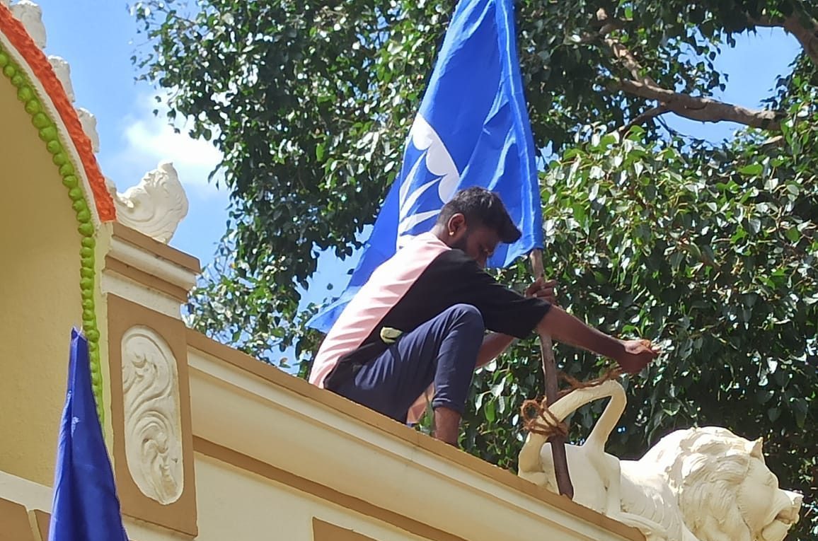 A Dalit agitator tying the flag to the lion's tail on Bhoothamma temple top in Ullerahalli