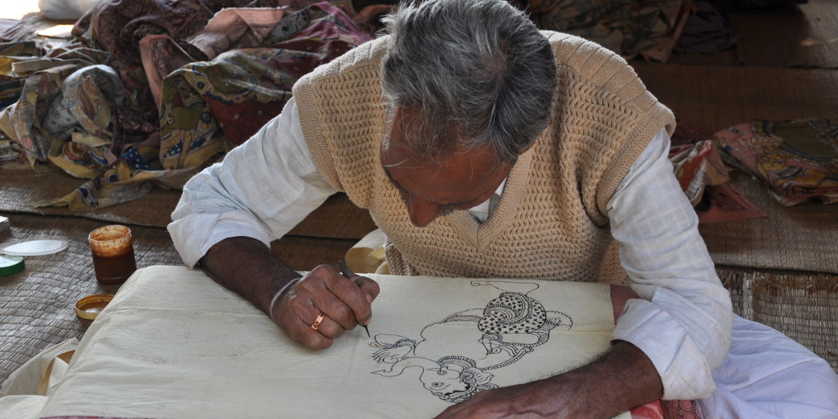 A kalamkari artisan hand-painting designs. (Wikimedia Commons)