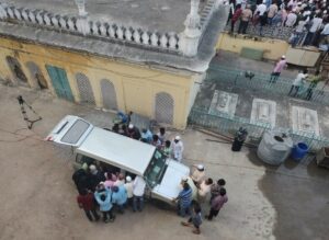 People watching the live telecast of the funeral of Hyderabad Nizam Mukarram Jah in a media van besides the Makkah Masjid.