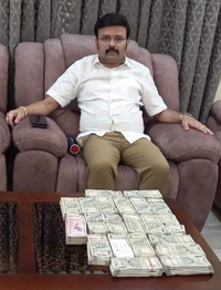 Leaked photograph of Santro Ravi posing with piles of cash. (Karnataka Congress/Twitter)