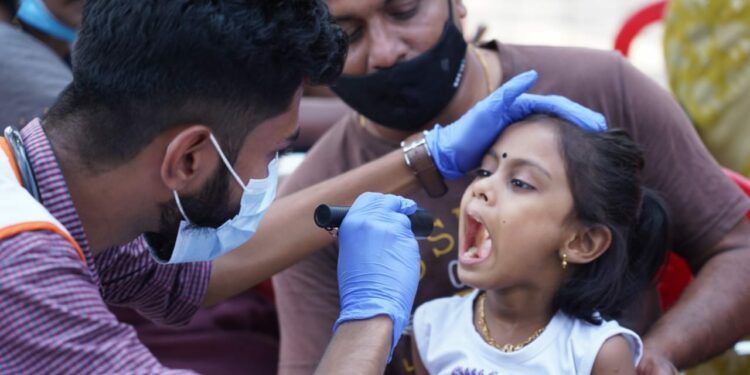 A doctor attached to the mobile unit of the health department checks a child at Vennala, Kochi, on Monday. (Facebook/District Collector)