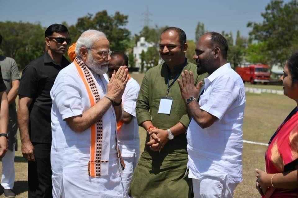PM Modi and 'Fighter' Ravi greeting each other at a helipad in Mandya