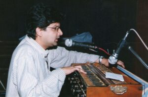 Raju Ananthaswamy playing the harmonium and singing