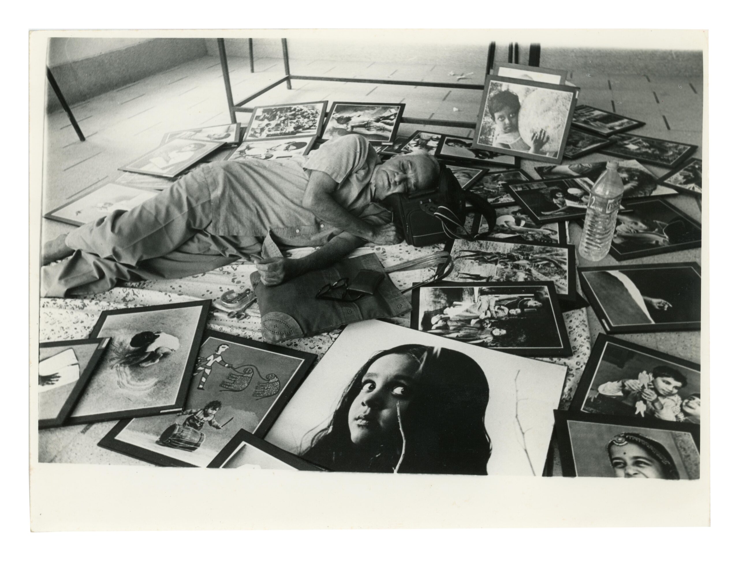 Photographer TS Satyan Sleeping Amidst his Exhibition Photographs Unknown 1999 Mysore (now Mysuru), Karnataka, India Silver gelatin print PHY.10348 Gifted by the TS Satyan Family Trust (Museum of Art & Photography, Bengaluru)