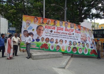 Officials from BBMP's Vasanthanagar Sub-division removing the illegal flex banner put up in front of the KPCC office in Bengaluru. (Supplied)