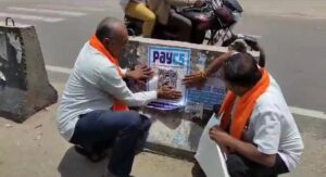 BJP workers sticking PayCS posters in Mandya on Thursday