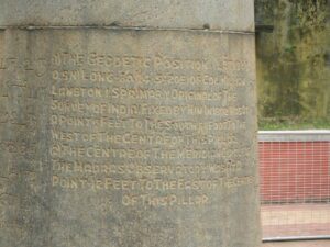 The pillar bears inscriptions in Tamil, Telugu, Urdu, and English.
