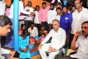 Health minister speaking to the girl Savitha and her family members at Kuratti Hosur in Chamarajnagar district. 