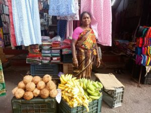 Street vendor Kala with three two crates of bananas and coconuts