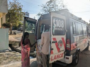 A woman from the Sharada Colony is being shifted in an ambulance to the primary health center and then to the Government hospital due to the severity of her condition.